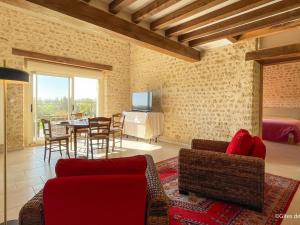 a living room with a red couch and a table at Charmante maison en pierres restaurée, WIFI, 2 ch. - FR-1-497-241 in La Mesniere