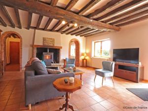 a living room with a couch and a tv at Maison de caractère avec jardin, idéale pour famille, animaux acceptés, randonnée, loisirs à proximité - FR-1-497-161 in Saint-Germain-de-Martigny