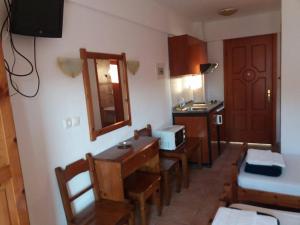 a kitchen with a table and chairs and a microwave at Hotel Kosmas in Sarti