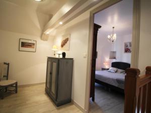 a bedroom with a bed and a chair and a mirror at Charmante maison normande 17e s., 2 chambres, jardin, Wi-Fi - FR-1-497-217 in Goulet