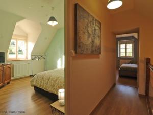 une chambre avec un lit et une télévision dans l'établissement Maison ancienne charmante avec jardin clos et spa extérieur - FR-1-497-168, à Le Pin-la-Garenne