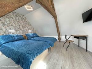 a bedroom with two beds with blue sheets and a table at Charmante maison près de Domfront avec 3 ch, animaux admis - FR-1-497-201 in Saint-Gilles-des-Marais