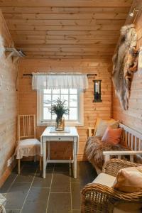 a living room with a table in a log cabin at Family Cabin With Shelter By Lake Gautetjern in Gol