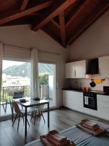 a living room with a table and a kitchen at Appartamenti Del Borgo in Borgosesia