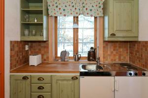 a kitchen with a sink and a window at Cozy Cottage By Töcksfors Lakes in Töcksfors
