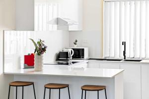 CabramattaにあるSerene Single Room in Canley Vale - Steps to Train & Local Dining - Shared Bathroomの白いカウンタートップと3脚のスツールを備えたキッチン +28枚の写真