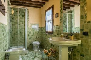 モンタイオーネにあるHistoric Villa With Tuscan Hills Viewの緑のタイル張りのバスルーム(洗面台、トイレ付) +21枚の写真