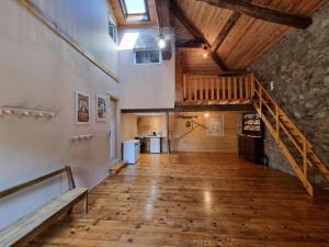 a large room with a wooden floor and a staircase at Gîte spacieux 10 pers: Nature, Spa, Confort - FR-1-496-358 in Saint-Denis-sur-Coise