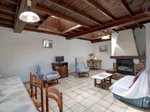 Gîte familial avec jeux extérieurs près de St-Galmier - FR-1-496-281 في Saint-Médard-en-Forez: غرفة معيشة مع أريكة ومدفأة