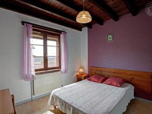 Gîte familial avec jeux extérieurs près de St-Galmier - FR-1-496-281 في Saint-Médard-en-Forez: غرفة نوم مع سرير بجدران وردية ونافذة