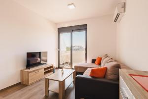 a living room with a couch and a tv at Apartment L'ideal in Ulcinj