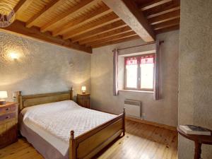 a bedroom with a wooden bed and a window at Chalet familial à 5 min des pistes de ski de Chalmazel, 3 chambres, cheminée, animaux acceptés - FR-1-496-138 in Le Champas