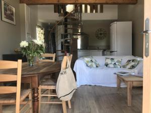 a living room with a table and a couch at Gîte charmeur avec piscine, Wi-Fi & animaux admis - FR-1-496-143 in Saint-André-dʼApchon