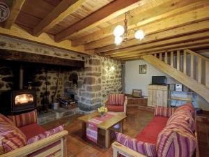 un soggiorno con camino e parete in pietra di Charmant Gîte avec Terrasse, Cheminée et Jardin, à Proximité des Bois, Animaux Acceptés - FR-1-496-205 a Saint-Jean-Soleymieux