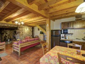 una cucina e un soggiorno con tavolo e frigorifero di Charmant Gîte avec Terrasse, Cheminée et Jardin, à Proximité des Bois, Animaux Acceptés - FR-1-496-205 a Saint-Jean-Soleymieux