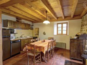 una cucina e una sala da pranzo con tavolo e sedie di Charmant Gîte avec Terrasse, Cheminée et Jardin, à Proximité des Bois, Animaux Acceptés - FR-1-496-205 a Saint-Jean-Soleymieux Altre 9 foto