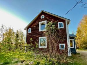 a red house with white windows on the side of it at Rural Magic In The Heart Of Nature in Krokströmmen