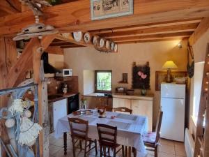 a kitchen with a table and a white refrigerator at Gîte charmant avec jardin privatif, proche sites historiques et activités de plein air - FR-1-496-183 in Cuinzier +20 photos