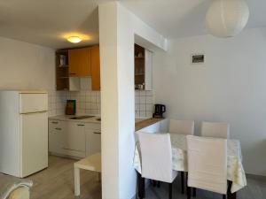 een keuken en eetkamer met een tafel en stoelen bij Apartments Parać in Petrcane