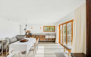 a kitchen and living room with a white table and chairs at Sea View And Idyll In Bungenäs On Gotland in Fårösund