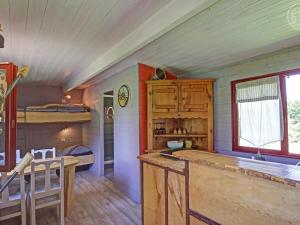 Cette chambre comprend une cuisine et des lits superposés. dans l'établissement Roulotte du Chat qui Pète: Séjour Paisible et Animaux Bienvenus - FR-1-496-308, à Saint-Germain-Lespinasse