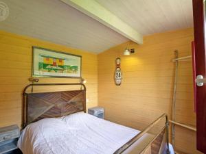 - une chambre avec un lit dans une pièce aux murs jaunes dans l'établissement Roulotte du Chat qui Pète: Séjour Paisible et Animaux Bienvenus - FR-1-496-308, à Saint-Germain-Lespinasse