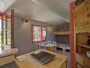 Cette chambre comprend une table et des lits superposés. dans l'établissement Roulotte du Chat qui Pète: Séjour Paisible et Animaux Bienvenus - FR-1-496-308, à Saint-Germain-Lespinasse 7 autres photos