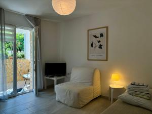 een woonkamer met een gele stoel en een televisie bij Apartments Parać in Petrcane