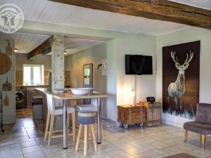 a kitchen with a counter and a table with a deer on the wall at Gîte familial 14 pers. avec piscine chauffée, spa, sauna, terrains de jeux et borne électrique. - FR-1-496-3 in Vivans
