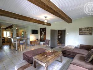 a living room with a couch and a table at Gîte familial 14 pers. avec piscine chauffée, spa, sauna, terrains de jeux et borne électrique. - FR-1-496-3 in Vivans