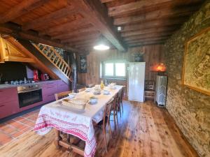Un comedor con una mesa y una cocina. en Gîte familial dans le massif du Pilat avec confort inclus - FR-1-496-294, en Doizieux