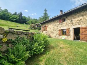 una casa de piedra con un muro de piedra y plantas en Gîte familial dans le massif du Pilat avec confort inclus - FR-1-496-294, en Doizieux