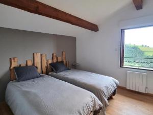 due letti in una stanza con finestra di Gîte rénové avec terrasse panoramique et tout confort à Saint-Chamond, proche Saint-Étienne et Lyon - FR-1-496-324 a Saint-Chamond