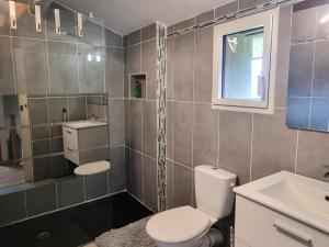 un bagno con un water, un lavandino e una finestra di Gîte rénové avec terrasse panoramique et tout confort à Saint-Chamond, proche Saint-Étienne et Lyon - FR-1-496-324 a Saint-Chamond Altre 11 foto