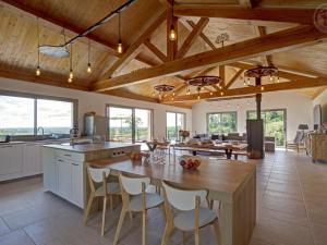 a kitchen with a large wooden table and chairs at Grande maison rénovée avec piscine chauffée, salle de jeux, pour 14 pers. à Sail-les-Bains - FR-1-496-301 in Sail-les-Bains