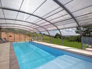 a swimming pool under a retractable roof at Grande maison rénovée avec piscine chauffée, salle de jeux, pour 14 pers. à Sail-les-Bains - FR-1-496-301 in Sail-les-Bains