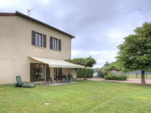 a house with a patio with a table and a tent at Gîte rustique avec wifi, animaux acceptés - FR-1-496-113 in Notre-Dame-de-Boisset