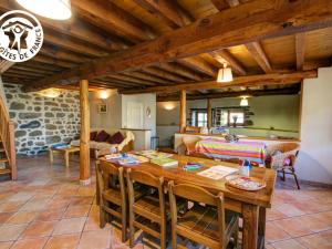 una cucina e un soggiorno con tavolo in legno di Gîtes de charme en pierre, animaux acceptés, jusqu'à 12 pers - FR-1-496-360 a Saint-Didier-sur-Rochefort