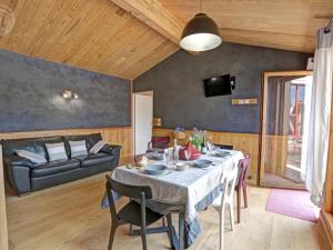 una sala da pranzo con un tavolo e un divano di Gîte de charme avec terrasses et plancha - FR-1-496-327 a Verrières-en-Forez