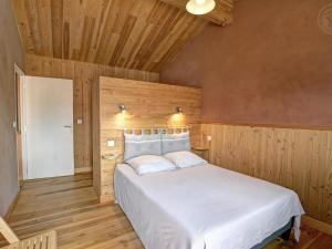 una camera con letto bianco e pareti in legno di Gîte de charme avec terrasses et plancha - FR-1-496-327 a Verrières-en-Forez