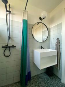 a bathroom with a white sink and a mirror at Modernized A-Frame House Near Saksild Beach in Odder
