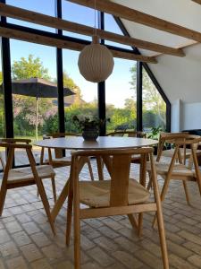 a table and chairs in a room with windows at Modernized A-Frame House Near Saksild Beach in Odder