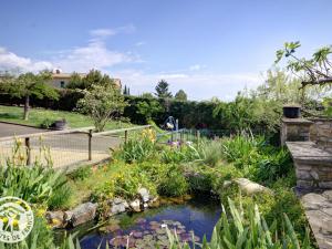 a garden with a pond with flowers in it at Gîte charmant au cœur du vignoble de Malleval - FR-1-496-116 in Malleval