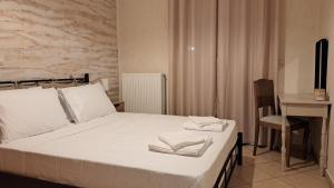 (( Agía Eleoúsa ))La Fragolina的一间卧室配有一张带白色床单的床和一张书桌。