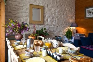 a dining room table with food and drinks on it at Chambres de la Ville d'Ys in Cléden-Cap-Sizun