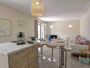 a kitchen and living room with a table and a couch at Charmant gîte moderne avec cour privée, tout équipé, parking sécurisé, au cœur du Roannais - FR-1-496-316 in Riorges +15 photos