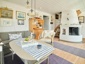 a living room with a table and a fireplace at Beachfront Gem With Outdoor Kitchen In Hvaler in Skjærhollen
