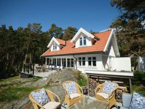 a white house with chairs in front of it at Beachfront Gem With Outdoor Kitchen In Hvaler in Skjærhollen
