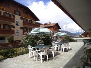 two tables and chairs with umbrellas in front of a building at Residence Ables in Valfurva