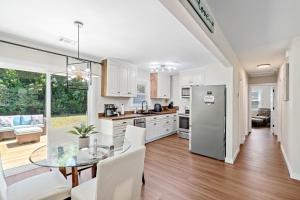 Una cocina y un comedor con una mesa de cristal. en Cottage Under the Magnolia Trees, en Beaufort